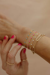 dainty gold layering bracelet with pop of color
